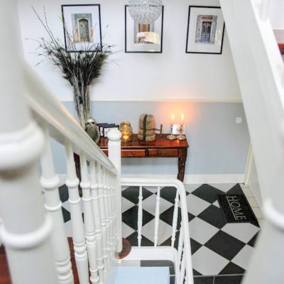 Gerenoveerd monumentaal trappenhuis met zwart witte tegels en sierlijke trapleuning