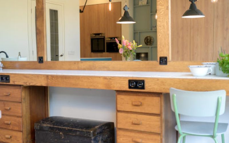 Duurzaam verbouwd interieur met maatwerk kast en ecostuc vloer en hergebruikte meubels en behoud van de antieke kappers kaptafel